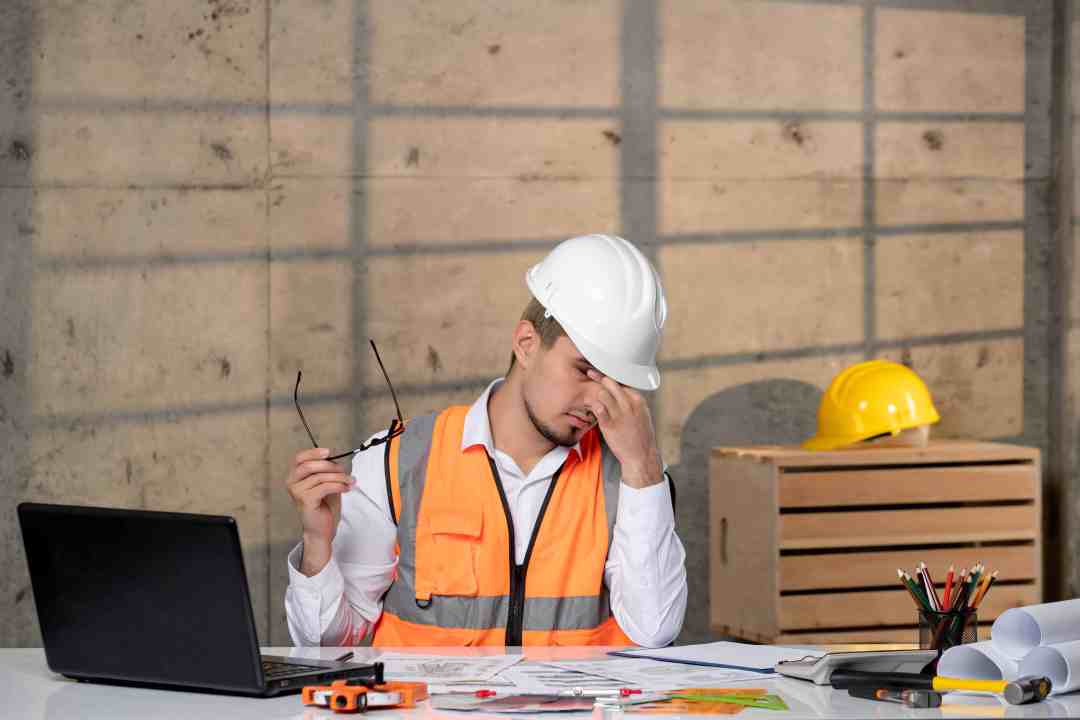 Subcontractor reviewing site plans with frustration, representing disconnected workflows, unclear scopes, and payment delays before using IntoAEC subcontractor management software.